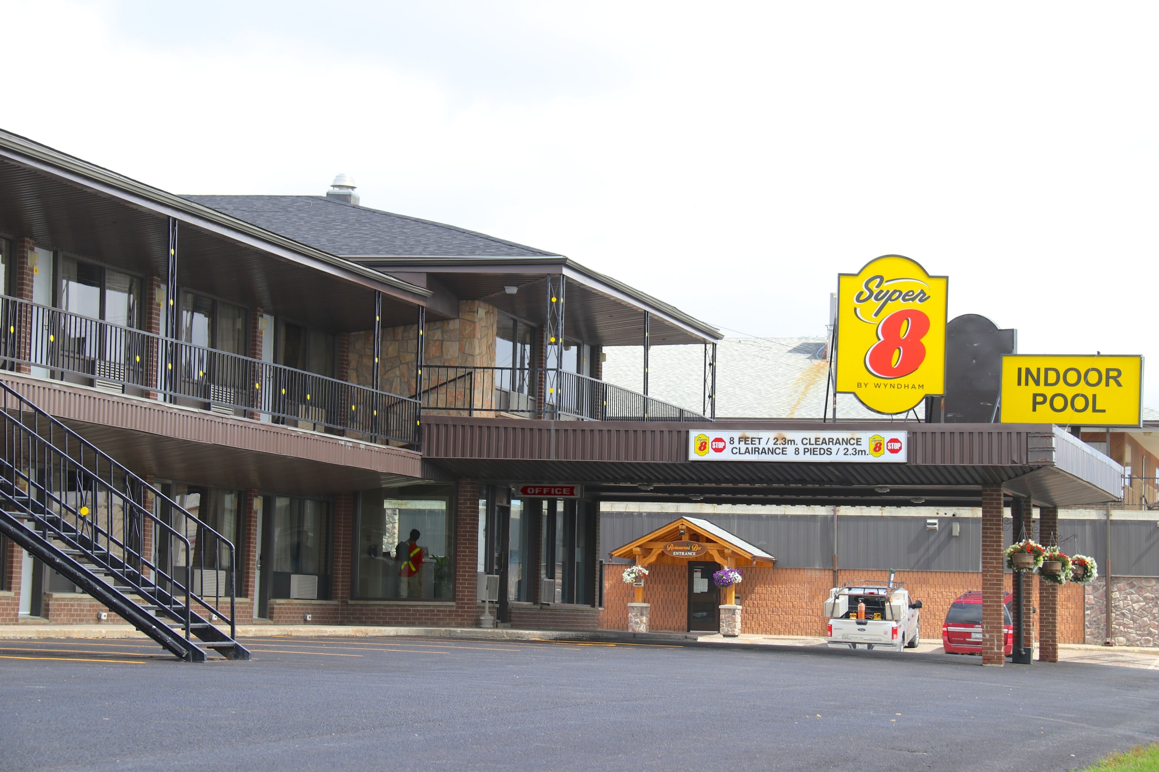 Un motel con un letrero que dice 'Super 8' y una 'PISCINA CUBIERTA'.