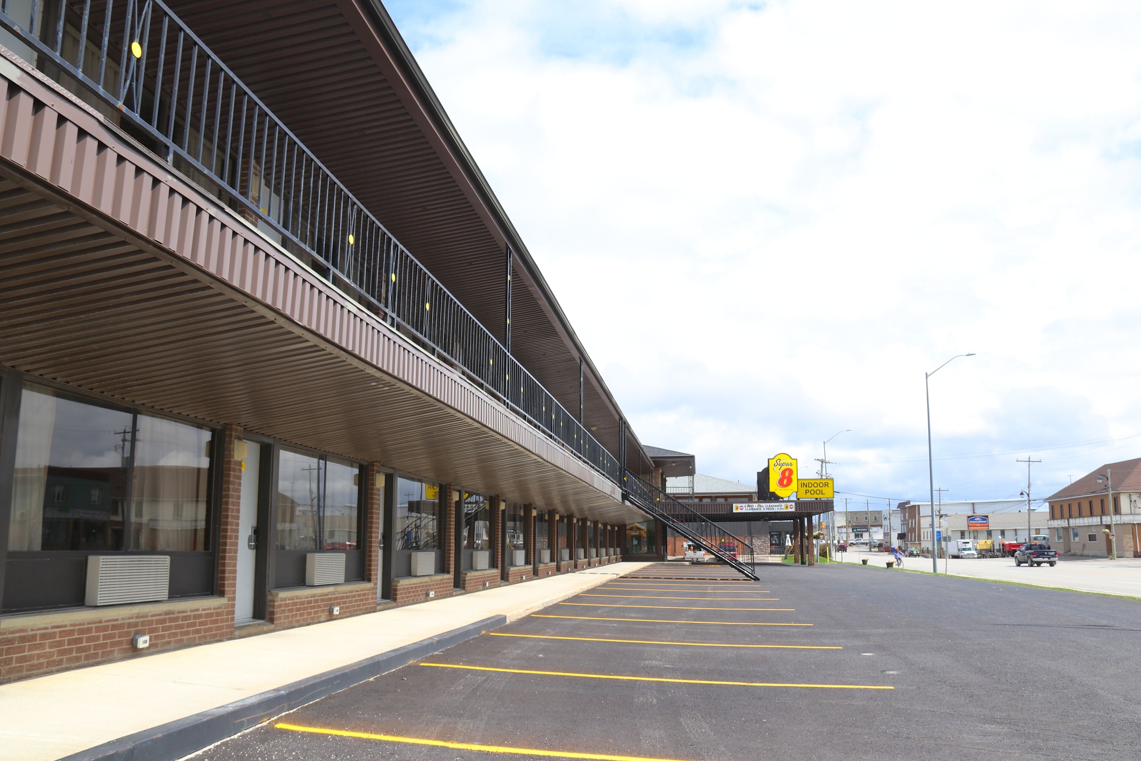 A building with a covered outdoor area, a sign for an indoor pool, and a parking lot.
