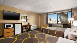 Habitación de hotel con dos camas, un escritorio, un televisor, microondas y vista panorámica de la ciudad.