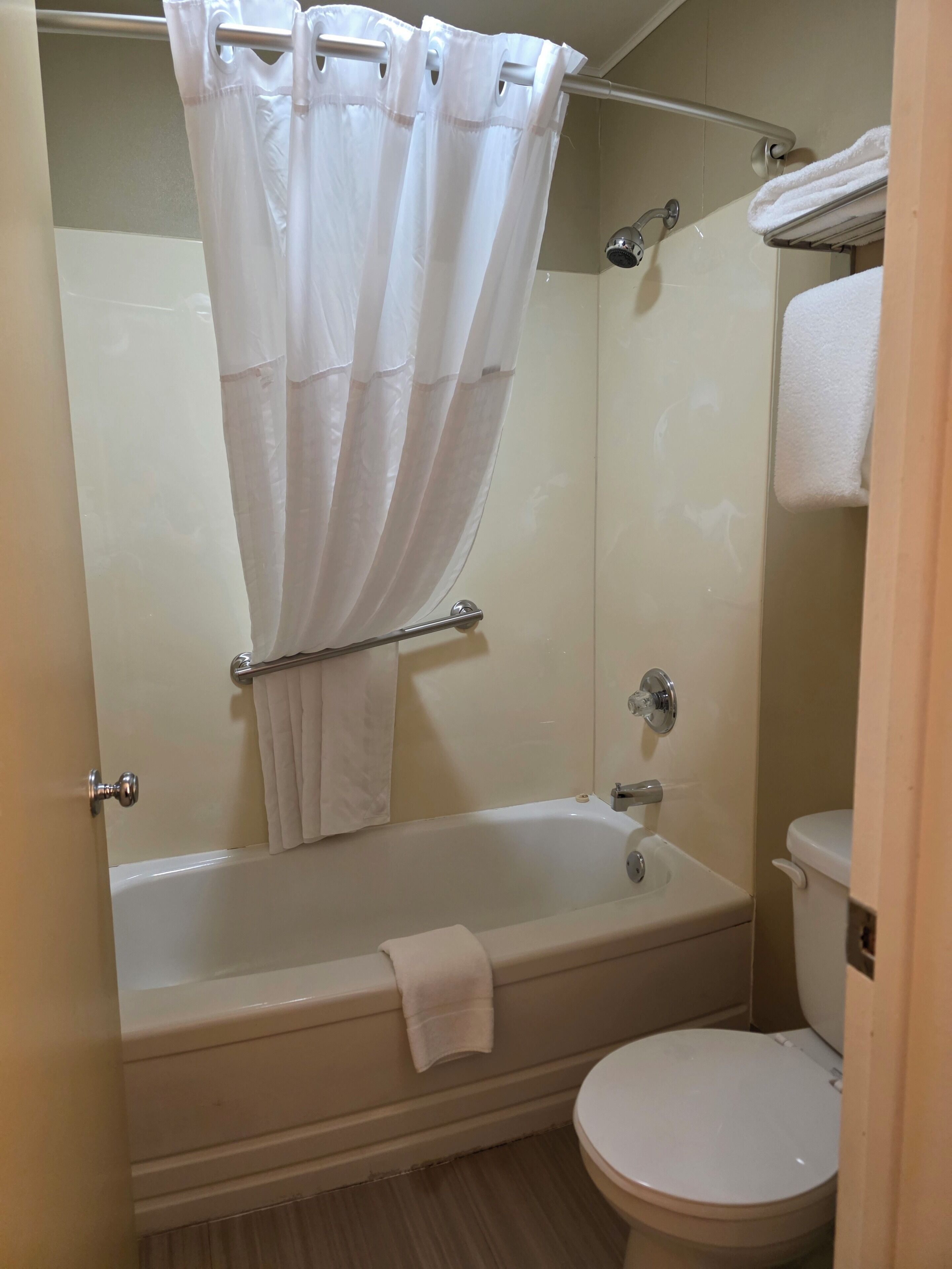 Un baño con bañera, inodoro y cortina de ducha.