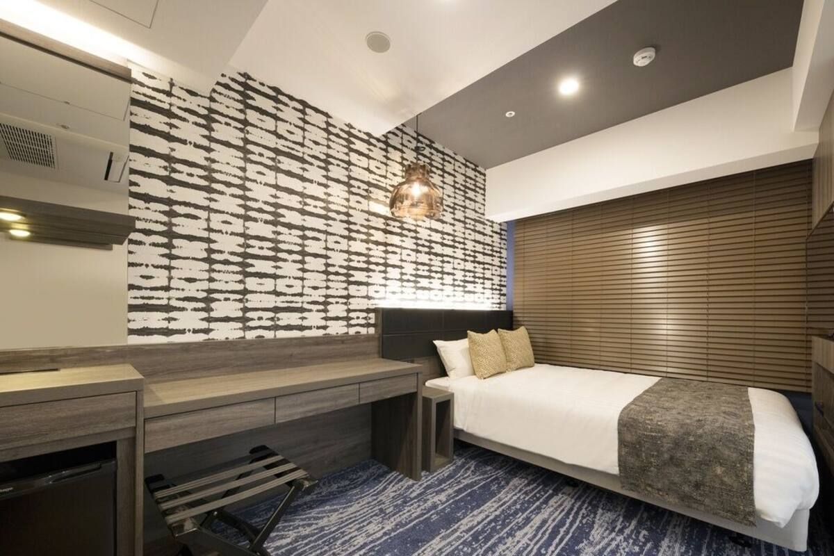 Ein modernes Hotelzimmer mit einem großen Bett, einem Schreibtisch und einer Wand mit Muster.