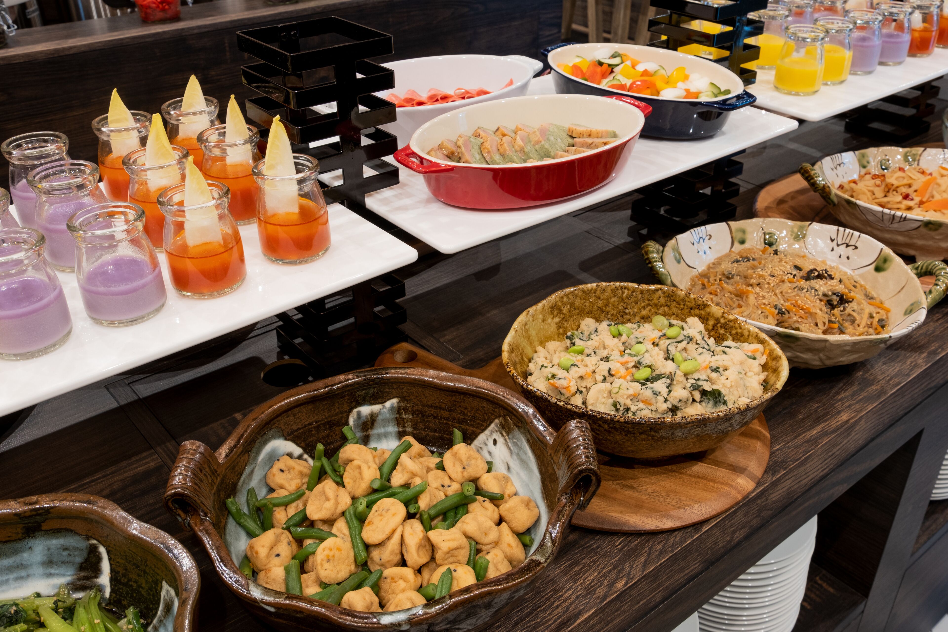 A buffet table with various dishes and drinks.