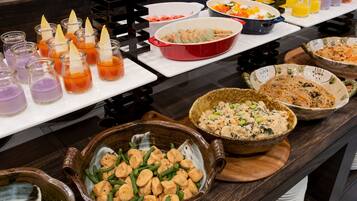 A buffet table with various dishes and drinks.