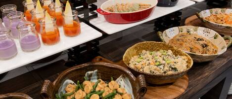 A buffet table with various dishes and drinks.