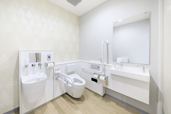 A modern bathroom with a bidet, toilet, and sink.
