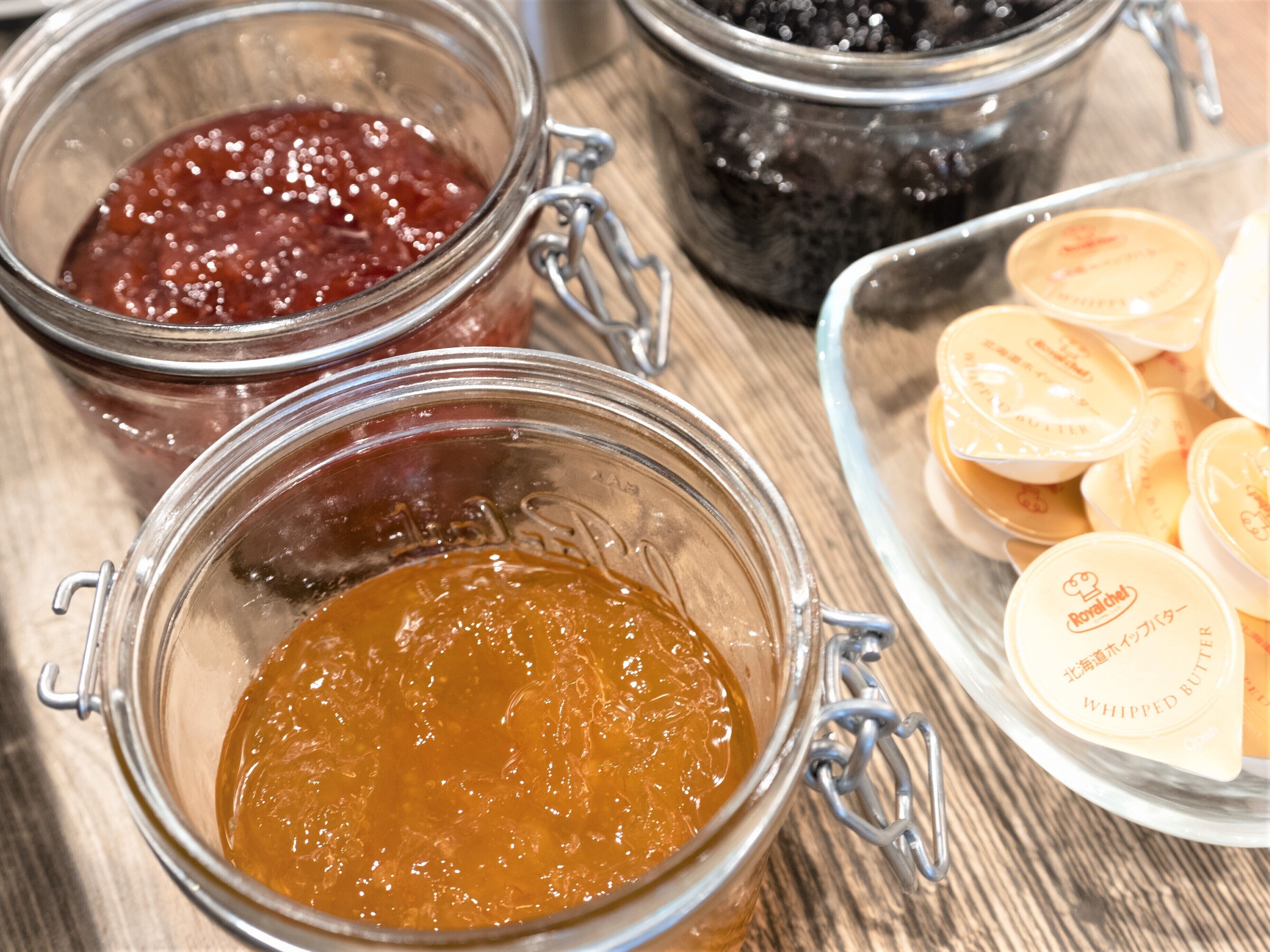 Tre glas med metalclips fyldt med forskellige slags marmelade.