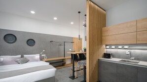 Een moderne slaapkamer met een bed, nachtkastje en een klein bureau met stoel.