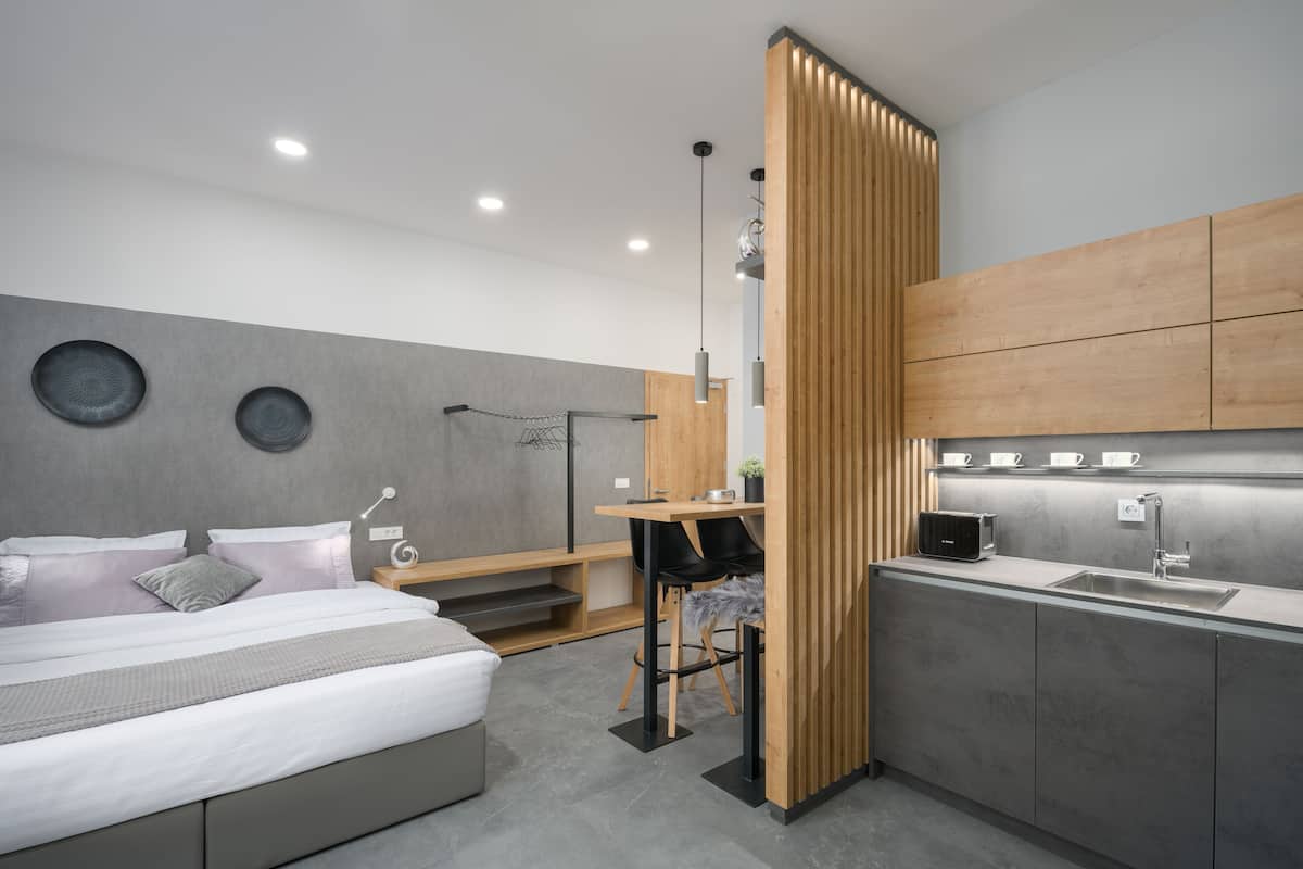 Een moderne slaapkamer met een bed, nachtkastje en een klein bureau met stoel.