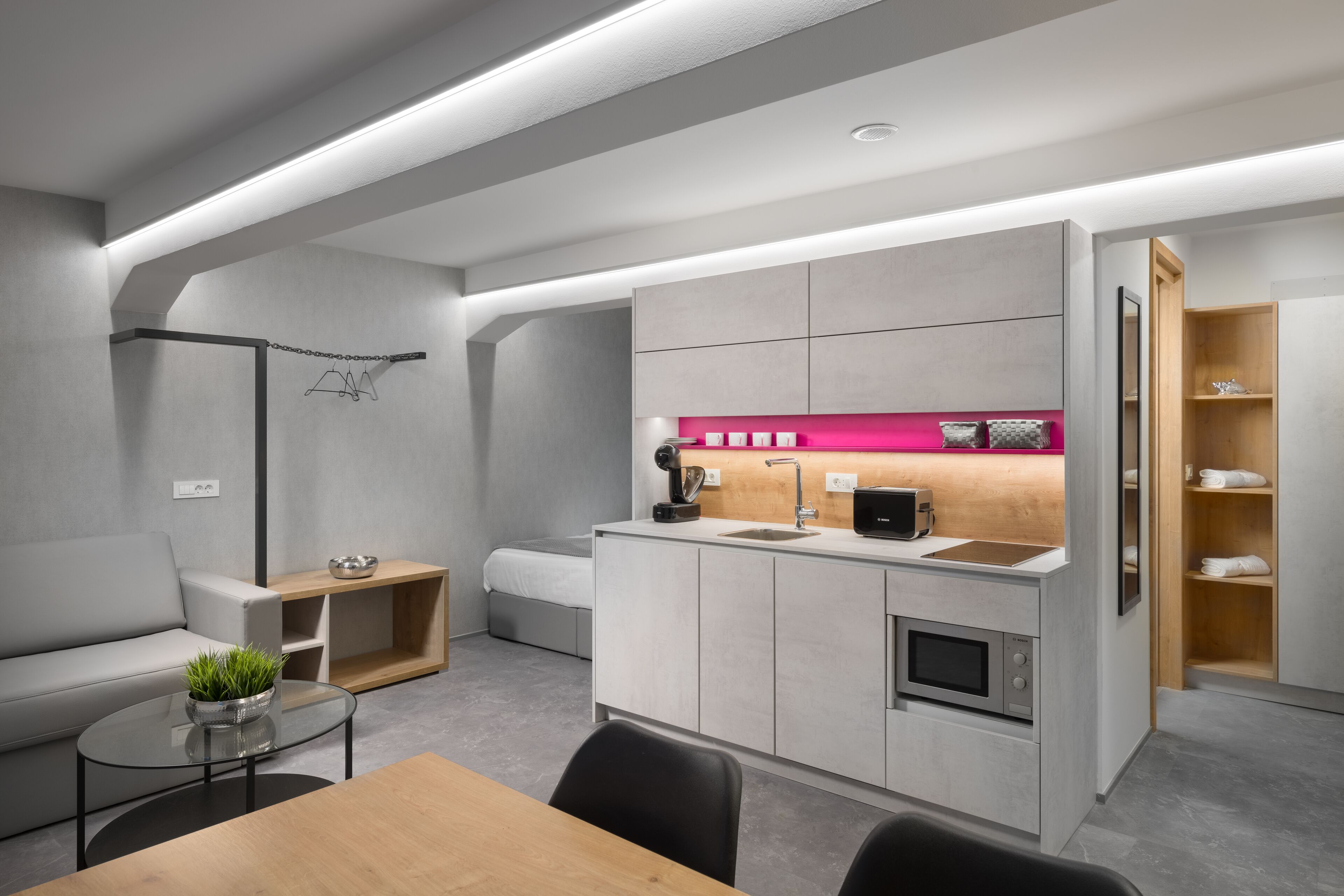 Eine moderne Küche mit integrierten Geräten, einem Essbereich mit Tisch und Stühlen sowie einer eingebauten Bank.
