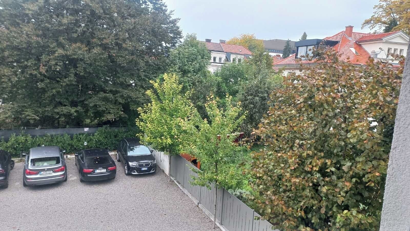 Un estacionamiento con coches y una valla.