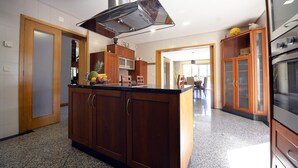 Cucina con pensili in legno, cappa in acciaio inossidabile e piano di lavoro in granito.