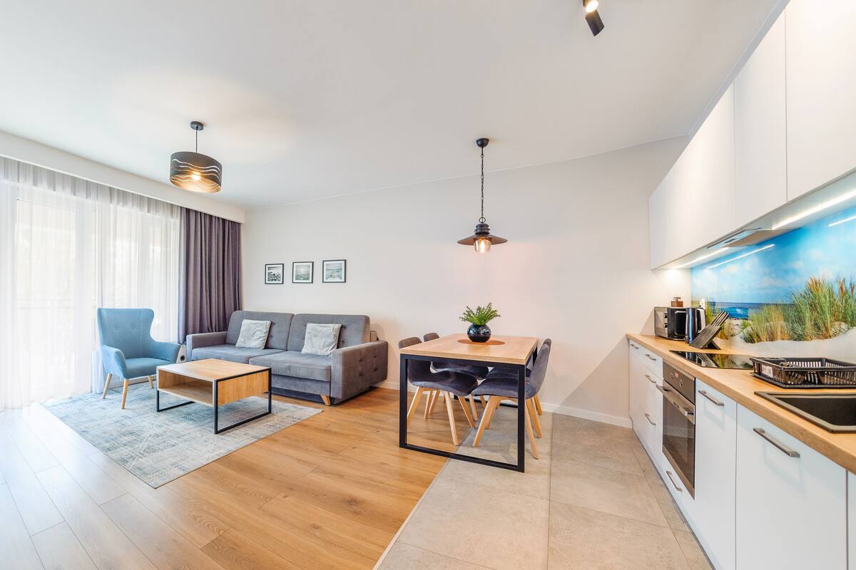 Een modern appartement met een woonkamer, eethoek en keuken.