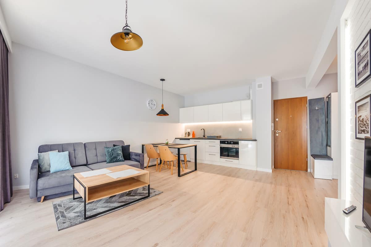 Een moderne woonkamer met een bank, salontafel en een eethoek.