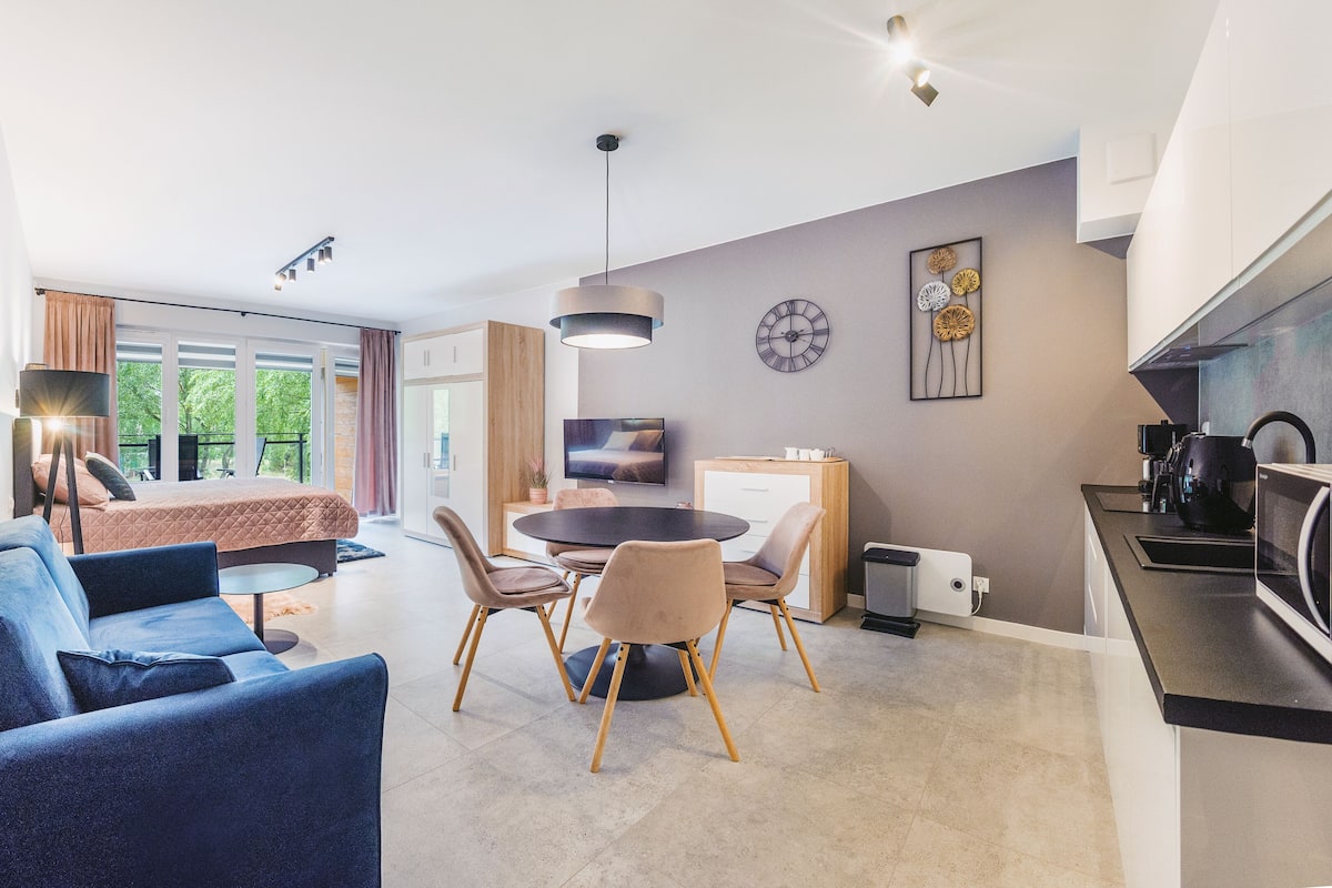 Een modern appartement met een woonkamer, eethoek en keuken.