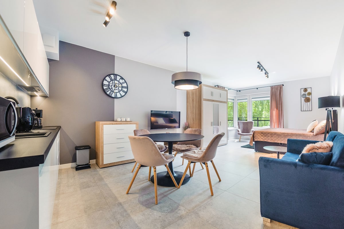 Een moderne keuken met een eethoek, een bank en een televisie.