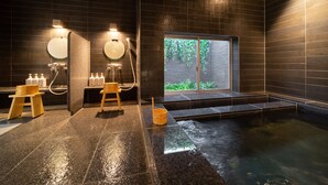 Ein modernes Spa mit Whirlpool, Holzschemeln und einem großen Fenster mit Blick auf Grünflächen.