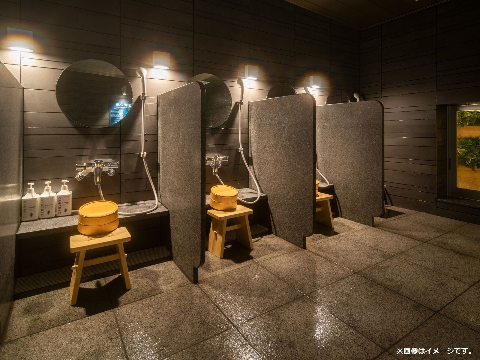 Ein modernes Badezimmer mit separaten Kabinen, ausgestattet mit Toilette, Waschbecken und Spiegel.