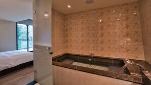 Un baño moderno con una bañera grande, ducha y cabina de ducha con mampara de vidrio.