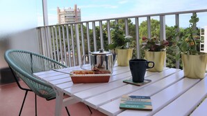 A balcony with a white table, a green chair, a coffee pot, a black mug, and three potted plants. - Pixie by the sea Design and connected apartment (La Baule-Escoublac)