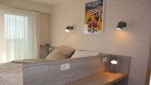 A bedroom with a bed, a desk, and two wall-mounted lamps. - Pixie by the sea Design and connected apartment (La Baule-Escoublac)