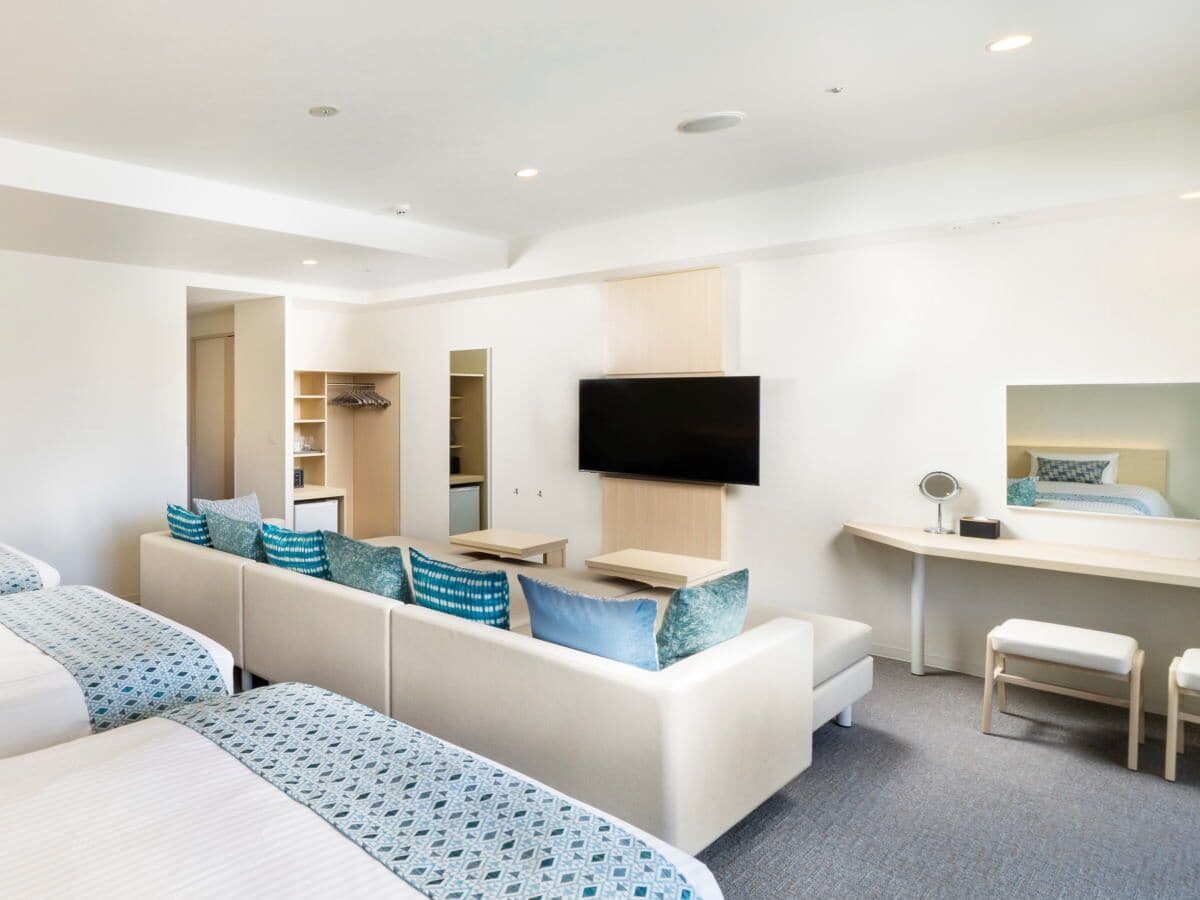 Een moderne hotelkamer met een groot bed, een sofa, een bureau en een televisie.