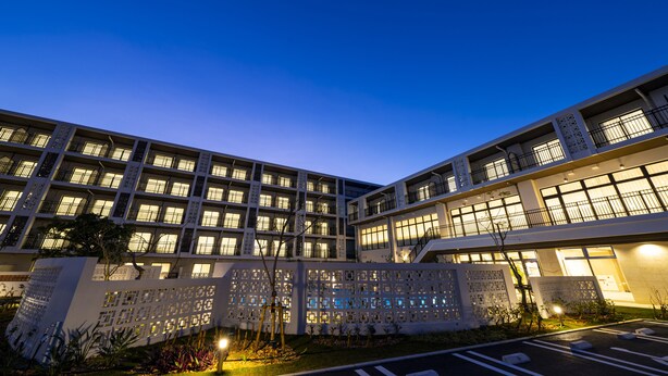 Un hôtel à plusieurs étages doté d’une architecture moderne, avec des balcons et de grandes fenêtres.