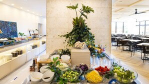 Un buffet proposant une variété de plats et agrémenté d’une plante décorative en guise de centre de table.