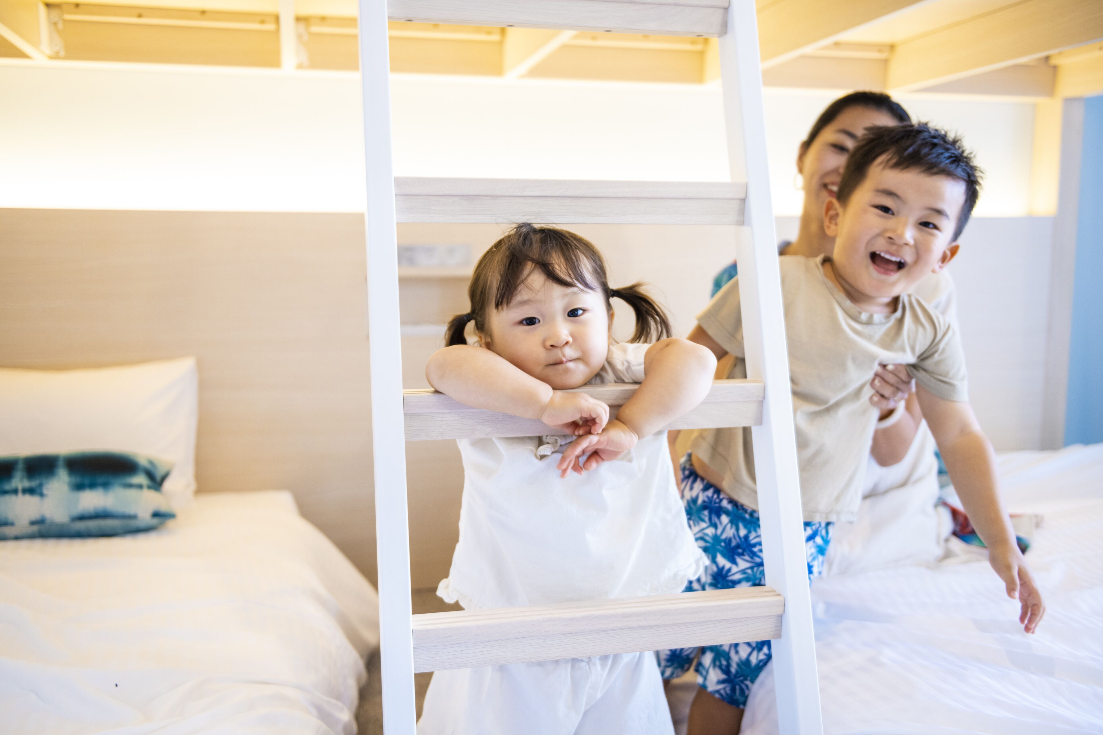A bunk bed with two children climbing on it.
