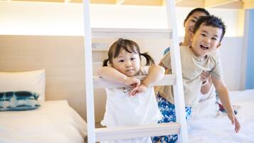A bunk bed with two children climbing on it.