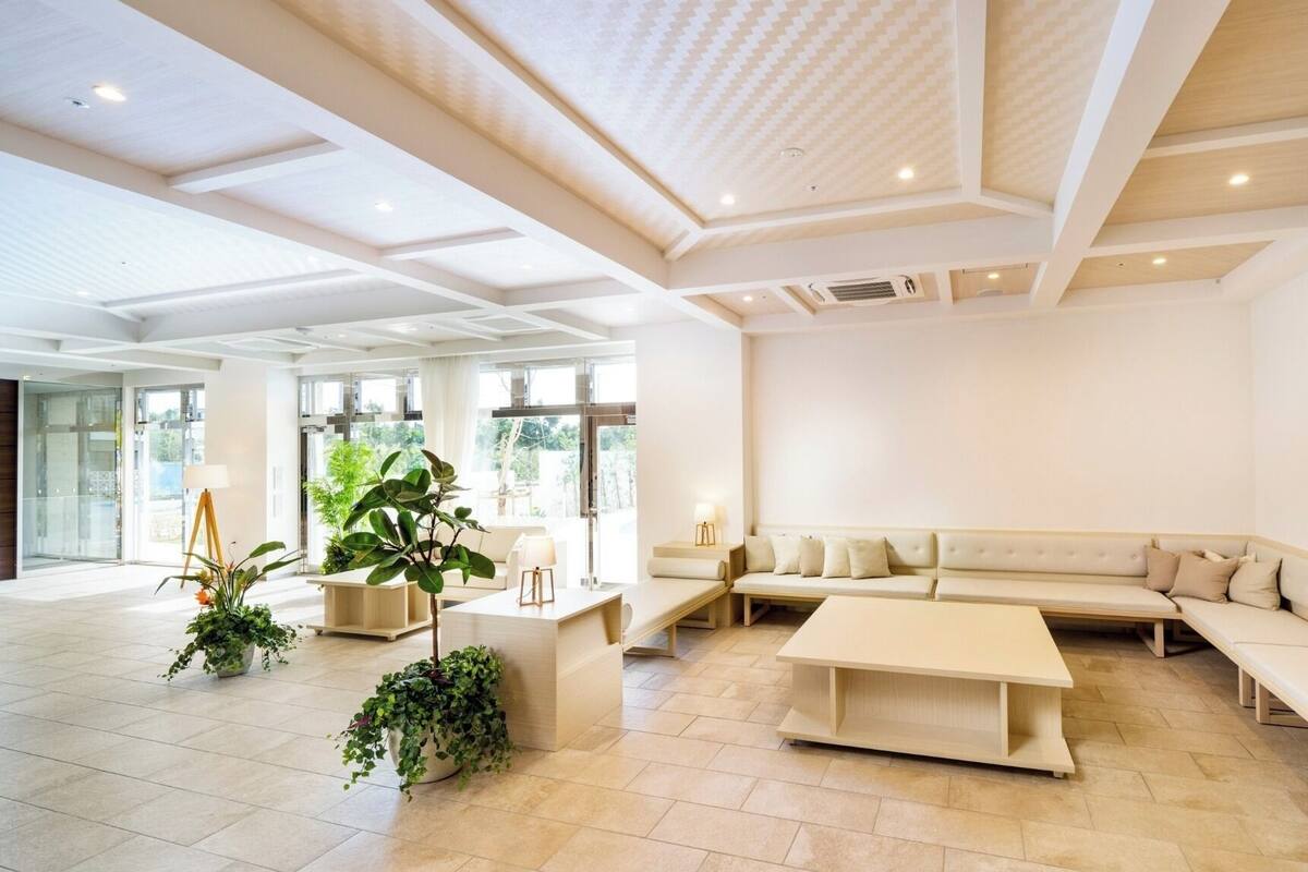 A spacious lobby with a large seating area, a coffee table, and potted plants.