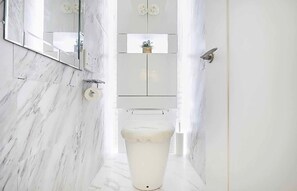 A bathroom with a marble floor, a toilet, a sink, and a mirror. - Reimi Mondo (Tokyo)