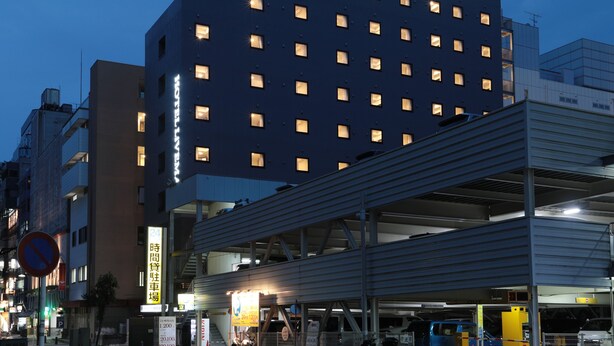 Un edificio de hotel con varios pisos y ventanas iluminadas, lo que sugiere que hay huéspedes.