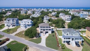 Et kystnært boligområde med flere toetagers huse, altaner og store vinduer.