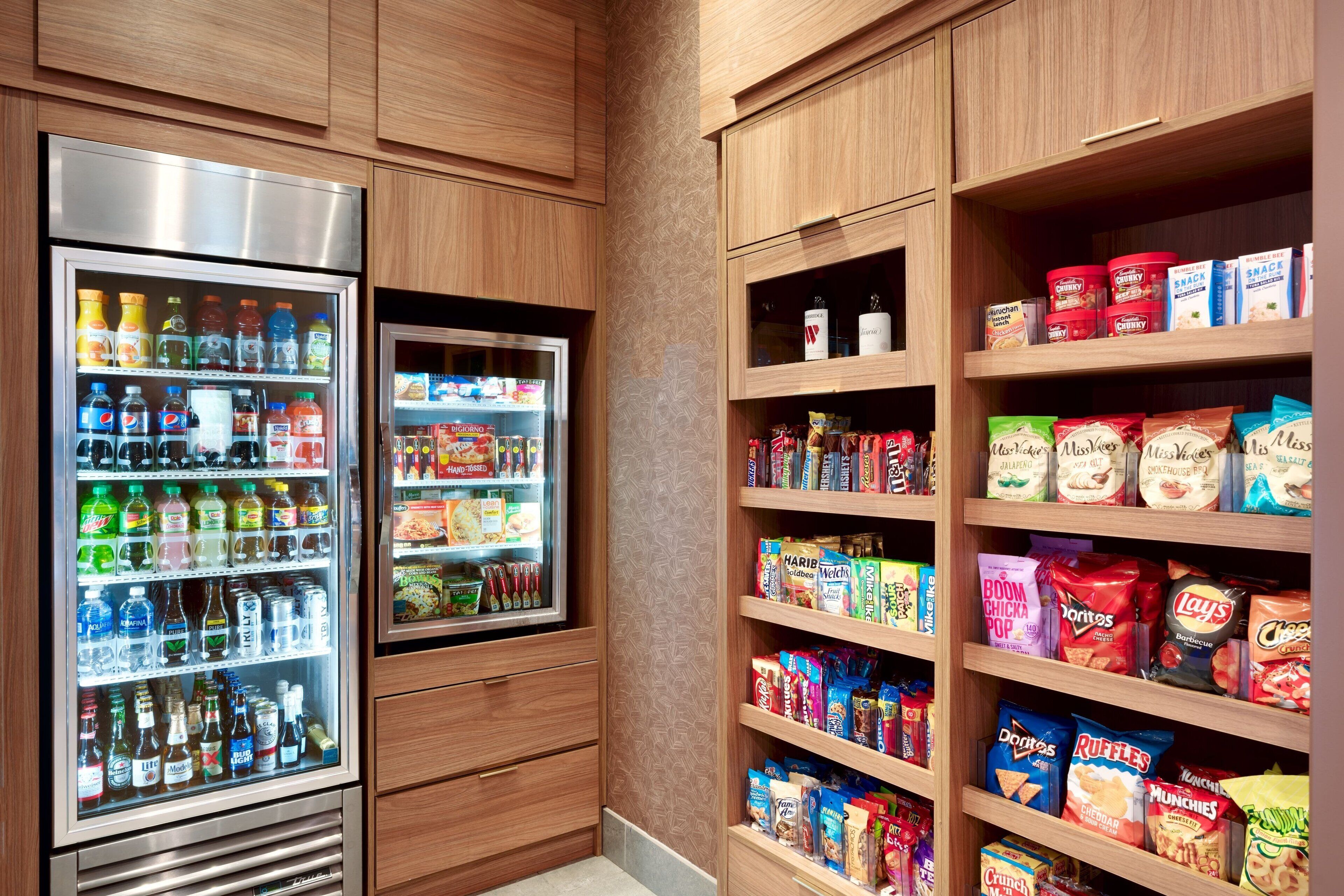 A snack and beverage vending area with multiple shelves stocked with various snacks and drinks.