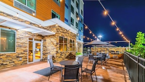 An outdoor patio area with stone walls, a wooden deck, and outdoor seating.
