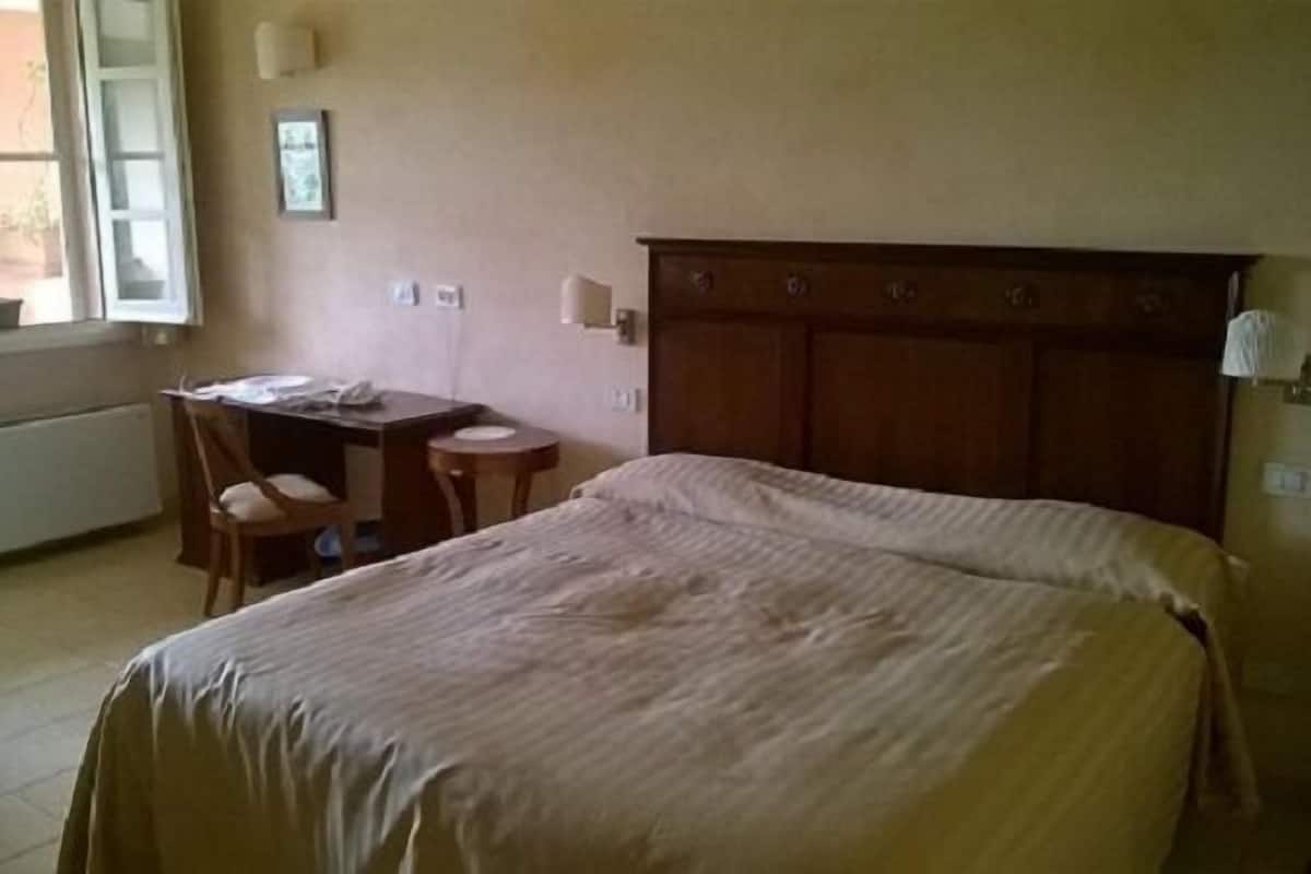 Une chambre d’hôtel avec un lit, un bureau et une chaise.