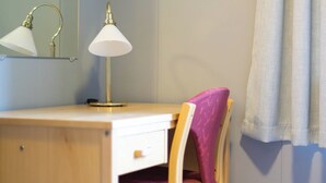A wooden desk with a white lamp, a mirror, and a pink chair in a room with light blue walls and a white curtain. - Havly Bed & Breakfast (Bremanger)