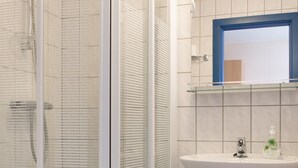 A modern bathroom with a glass shower enclosure, a white sink, and a toilet. - Havly Bed & Breakfast (Bremanger)