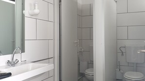 Un bany modern amb un rentapel, un mirall i un vàter.