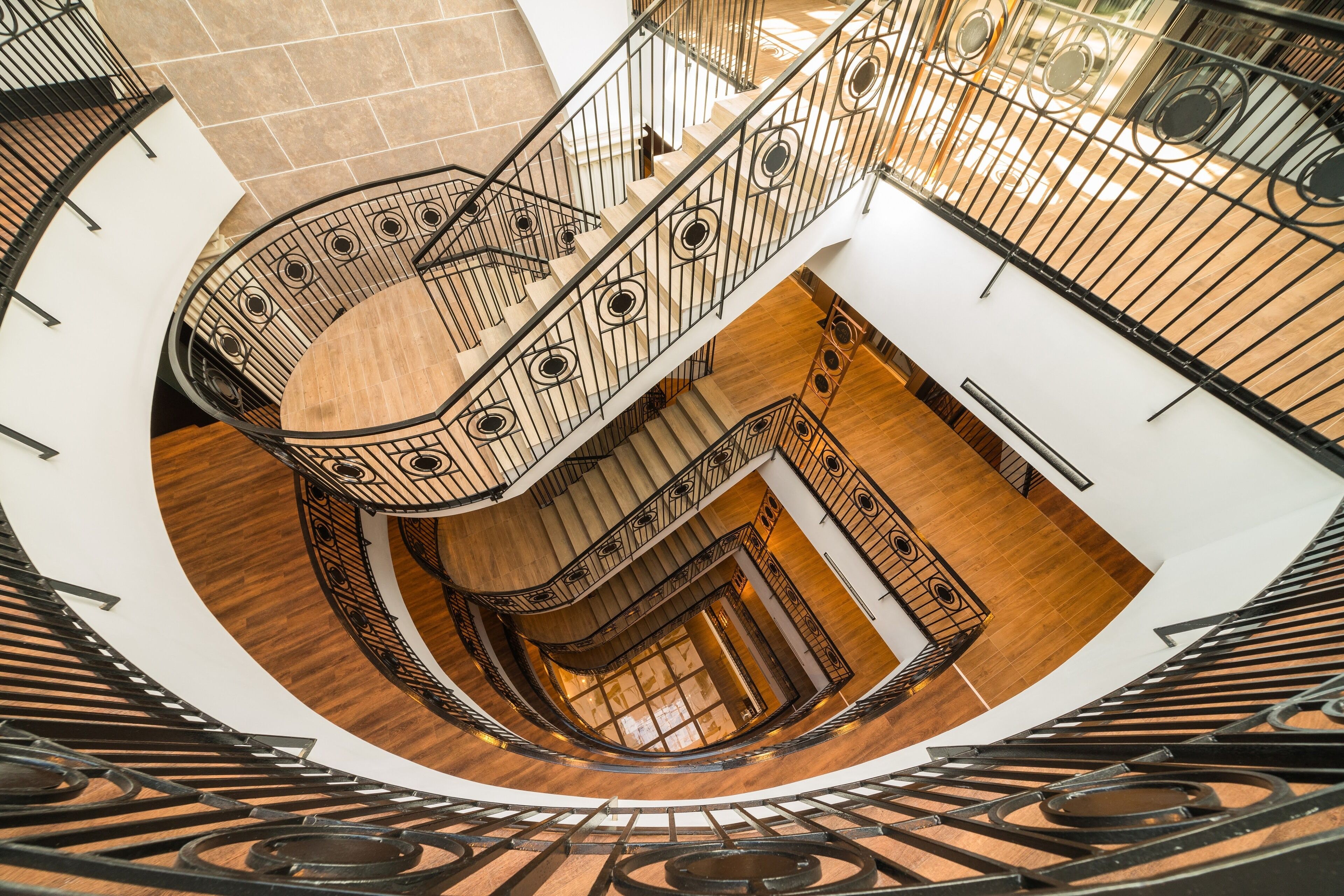 A spiral staircase with a wooden finish and metal railings.