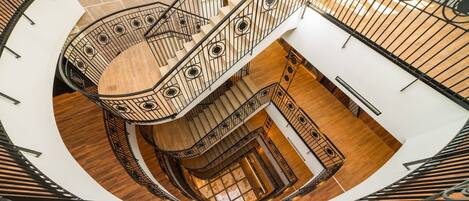 A spiral staircase with a wooden finish and metal railings.