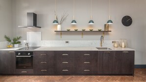A modern kitchen with a central island, built-in oven, and a stainless steel sink. - Ljubljana centre, river view, balcony & bikes (Ljubljana)