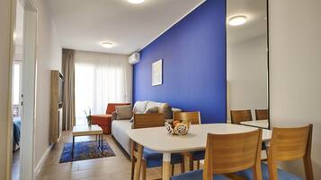 Una sala de estar moderna con comedor, pared de acento azul y un espejo grande.