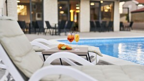Piscine extérieure en saison, parasols, chaises longues