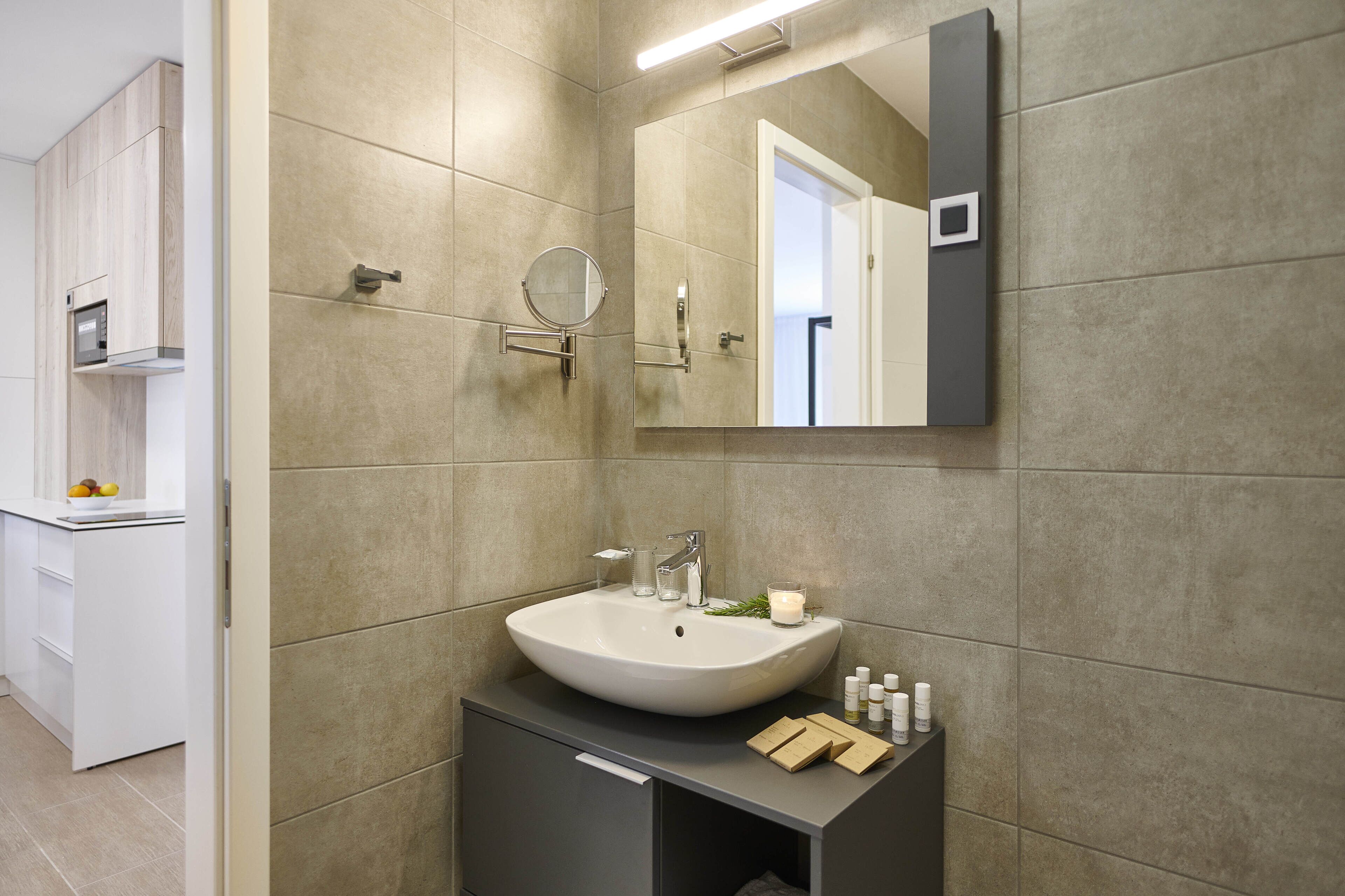 A modern bathroom with a large sink, mirror, and built-in cabinet.