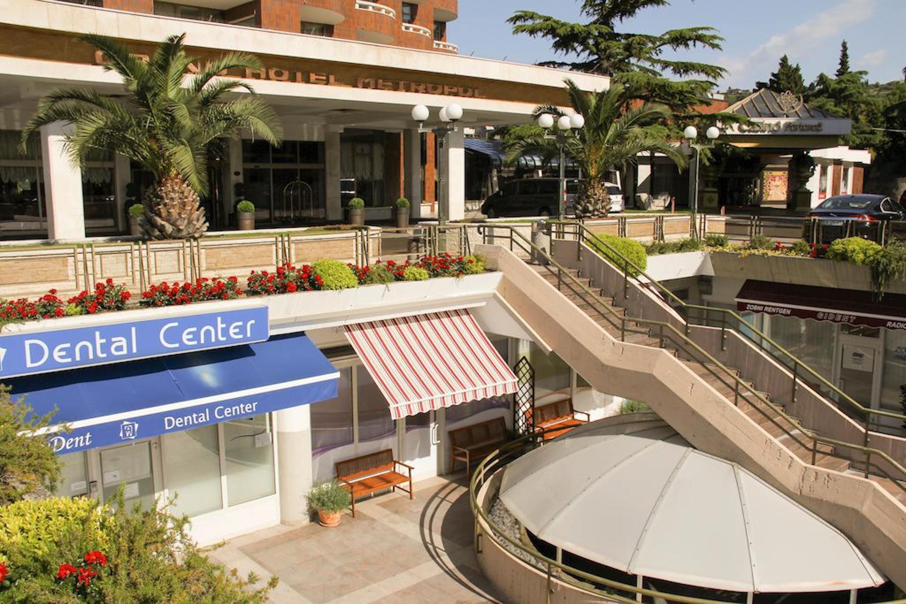 Un centro dentistico con insegna, posti a sedere all'aperto e una scala che conduce a un piano superiore.