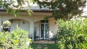 Een woning met een overdekte veranda, een deur en buitenfitnessapparatuur.