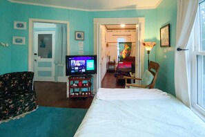 Habitació d'hotel amb llit, televisió, cadira i escriptori.