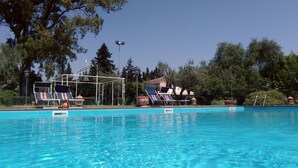 A swimming pool with lounge chairs and a pergola structure. - Casa Felice Uno - Contrada Guido (con piscina) (Sellia Marina)