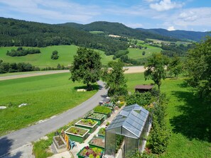A rural landscape with a road, greenhouses, and a small building. - Bauernhof Waira (Yspertal)